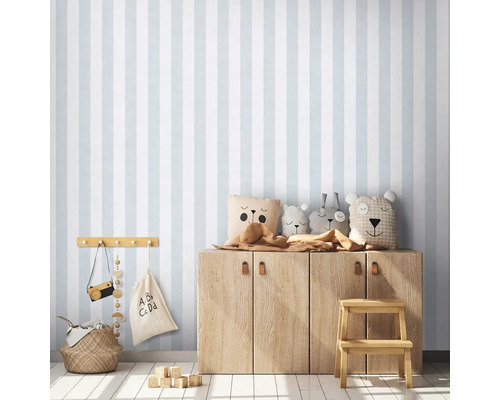 Kinderzimmer mit gestreifter Tapete, Holzschrank und Dekorationsartikeln