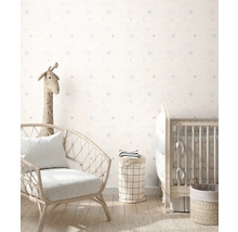 Kinderzimmer mit Sessel, Kinderbett und Aufbewahrungskörben vor einer Wand mit Punktmuster.