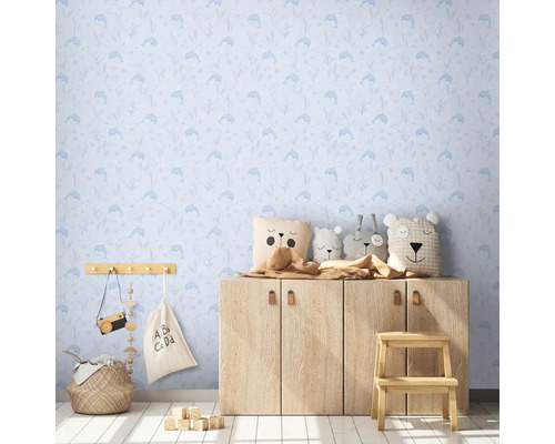 Kinderzimmer mit blauer Delfin Tapete, Holzkommode und Stofftieren.