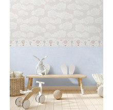 Kinderzimmer mit Wolken- und Ballonmustertapete, Holzbank, Stoffhase und Holzspielzeug