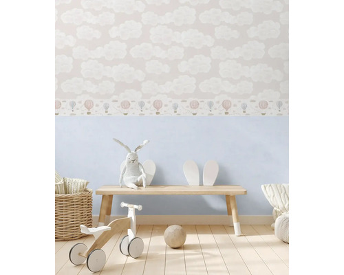 Kinderzimmer mit Wolken- und Ballonmustertapete, Holzbank, Stoffhase und Holzspielzeug