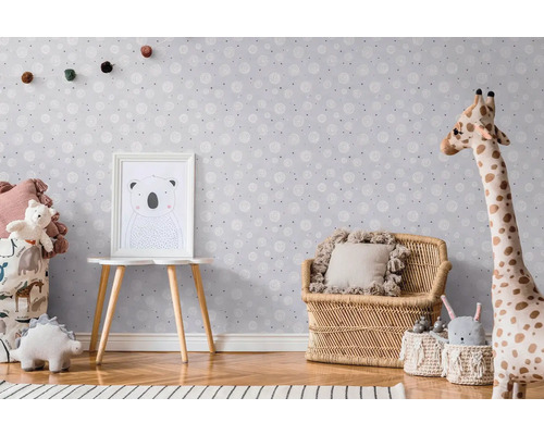 Kinderzimmer mit Tapete, Rattansessel und Spielzeug