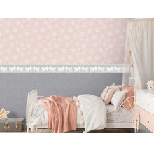 Kinderzimmer mit Bett, Nachttisch und rosafarbener Tapete mit Einhornmuster