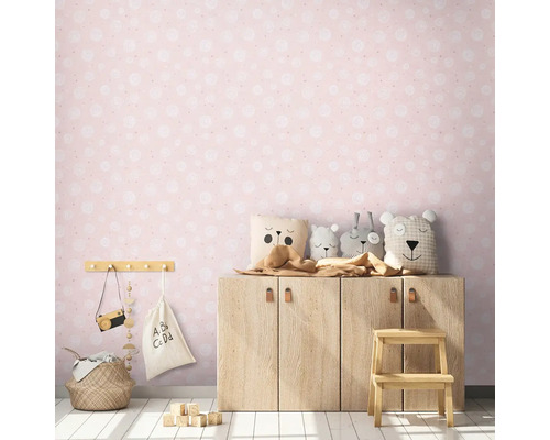 Kindgerechtes Zimmer mit rosa Tapete, Holzschrank und Stofftieren.