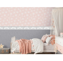 Kinderzimmer mit Bett, Nachttisch und rosa Tapete mit weißen Mustern