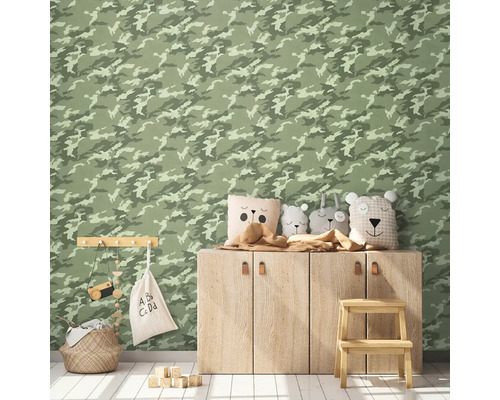 Dekoriertes Kinderzimmer mit Wandtapete im Camouflage Muster, Holzschrank, Dekokissen, Aufbewahrungskorb und Spielzeug