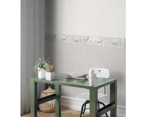 Dekoratives Arbeitszimmer mit Wandbordüre, Schreibtisch, Stuhl und Accessoires.