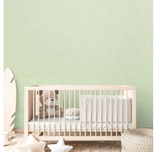 Kinderzimmer mit Gitterbett, Teddybär und dekorativen Elementen.