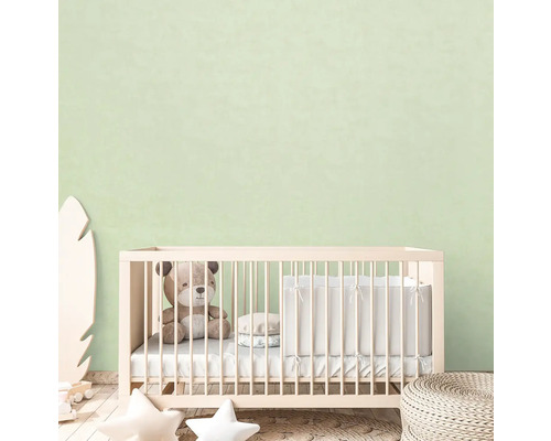 Kinderzimmer mit Gitterbett, Teddybär und dekorativen Elementen.
