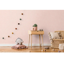 Kinderzimmer mit Holzkommode, Rattansessel und dekorativen Elementen
