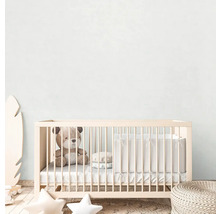 Ein Kinderzimmer mit einem Babybett, einem Teddybär und Dekorationen.