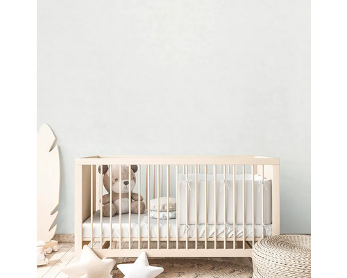 Ein Kinderzimmer mit einem Babybett, einem Teddybär und Dekorationen.