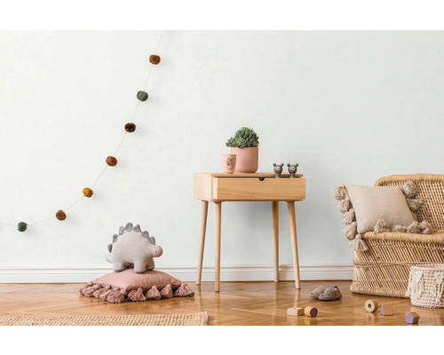 Kinderzimmer mit Holzkommode, Rattansessel und Dekorationsartikeln