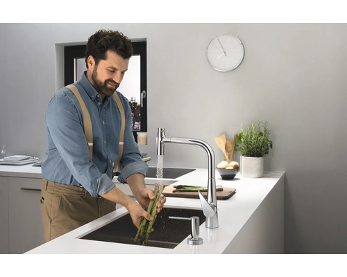 Mann wäscht Spargel in einer modernen Küche mit Spültischarmatur.