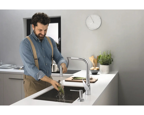 Mann wäscht Spargel in einer modernen Küche mit Spültischarmatur