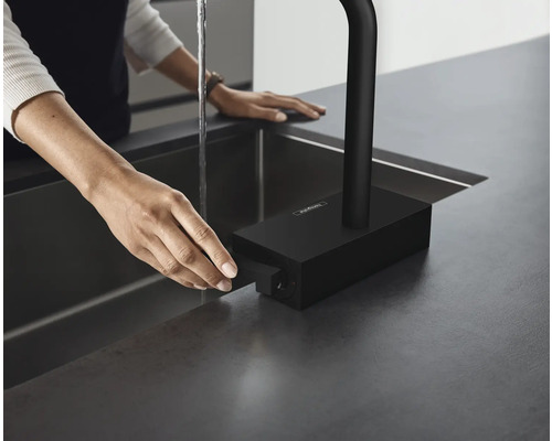Schwarze Küchenarmatur mit Bedienhebel an Spültisch mit Wasserhahn.