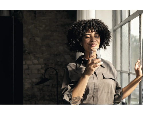 Frau mit Wasserglas am Fenster