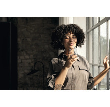 Frau mit Glas Wasser am Fenster
