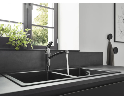 Spültisch mit zwei Becken und Wasserhahn in einer modern gestalteten Küche.