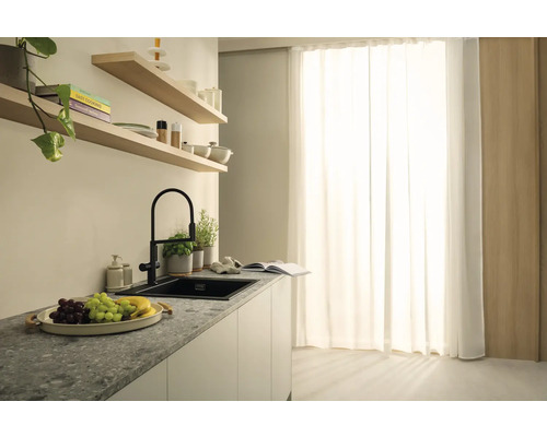 Küchenszene mit Spüle, Armatur und dekorativen Elementen auf einer Arbeitsplatte