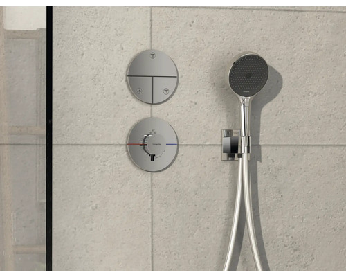 Duscharmatur mit Kopfbrause und Bedienelementen an einer gefliesten Wand