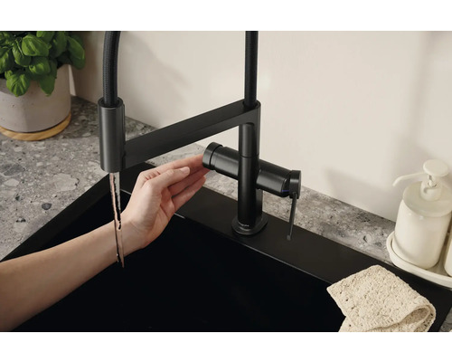 Schwenkbarer Küchenmischer mit Handbrause und modernem Design an einer Spüle.