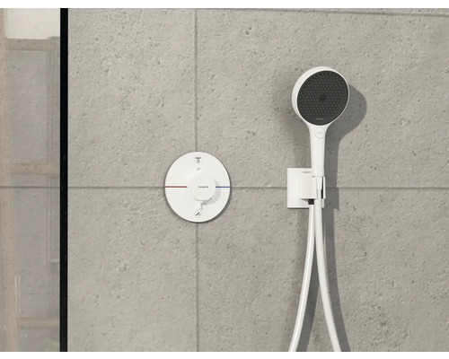 Hansgrohe Logo, Aufputz-Thermostat und Handbrause an einer grauen Wand