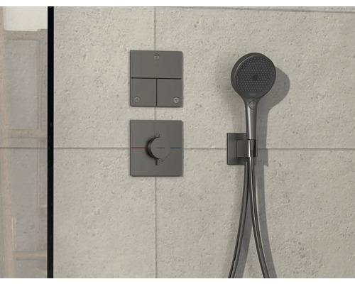 Brausegarnitur mit Armatur und Bedienelementen an gefliester Wand