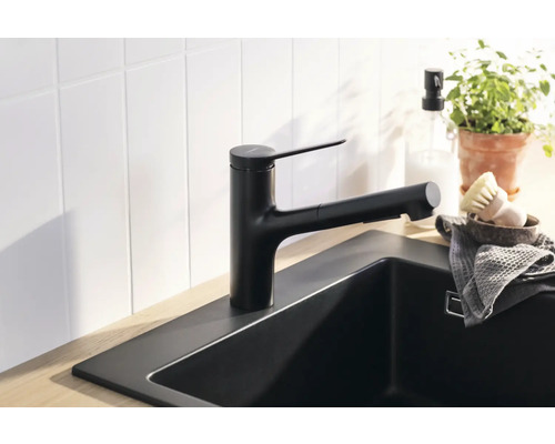 Schwarze Küchenarmatur mit ausziehbarer Brause an Spüle montiert.