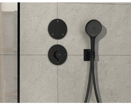 Schwarze Duscharmatur mit Handbrause an gefliester Wand