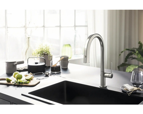 Küchenszene mit Spültischarmatur, Spüle und Küchenutensilien auf einer Arbeitsplatte.