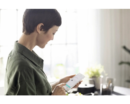 Frau benutzt ein Smartphone in einem hellen Raum für Online-Shopping.