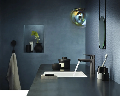 Modernes Badezimmer mit Waschtisch, Armatur, Spiegel und Dekorationsartikeln