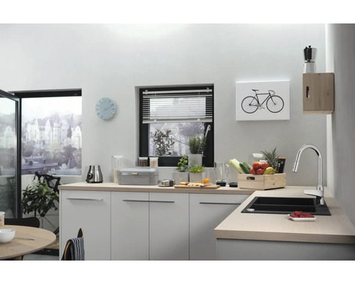 Helle Küche mit Spüle, Armatur, Küchenutensilien und Dekorationen