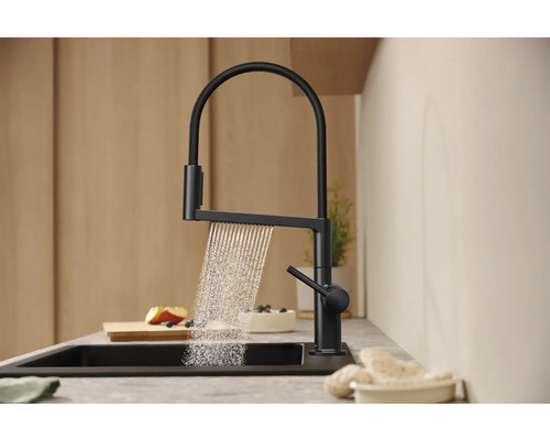 Schwarze Küchenarmatur mit Wasserstrahl in modernem Küchendesign