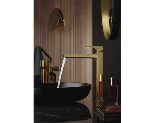 Goldene Armatur mit fließendem Wasser in einem Badezimmer mit schwarzem Waschbecken