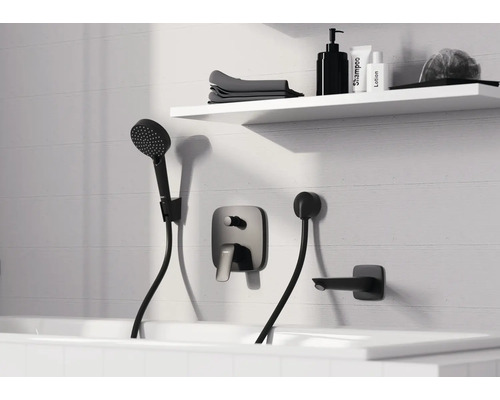 Badewannenarmatur-Set mit Handbrause an einer weißen Wand über einer Badewanne, im Hintergrund ein Regal mit Badutensilien