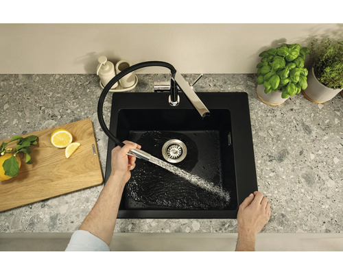Spüle mit Wasserhahn, Schneidebrett und Kräutertöpfen auf einer Arbeitsplatte