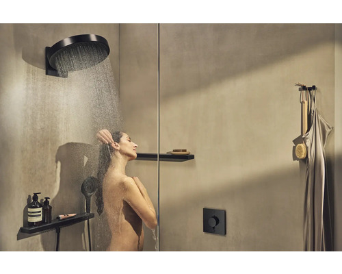 Frau unter einer Kopfbrause in einer modernen Dusche mit Armaturen