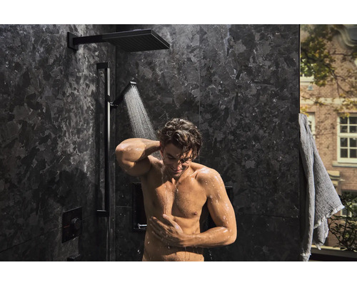 Moderne Dusche mit Kopfbrause und Handbrause in einem Badezimmer mit dunklen Fliesen