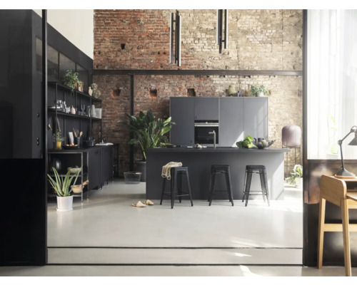 Helle Küche im Loftstil mit Kücheninsel, Barhockern und Regalen vor einer Backsteinwand.