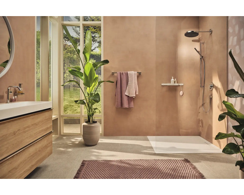 Helles Badezimmer mit Dusche, Waschtisch, Spiegel und Zimmerpflanzen für eine freundliche Atmosphäre.