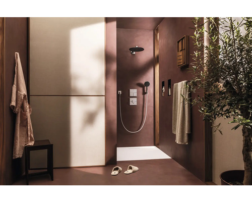 Badezimmer mit Dusche, Handtüchern, Hocker, Bademantel und Olivenbaum für eine angenehme Atmosphäre