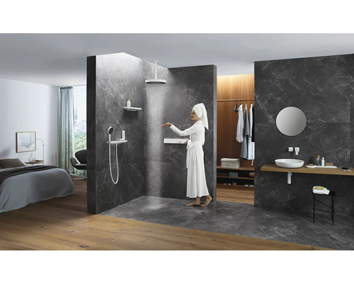 Badezimmer mit Dusche, Waschtisch und angrenzendem Schlafzimmer.