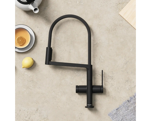 Schwarze Küchenarmatur mit hohem Auslauf neben Teekanne und Tasse