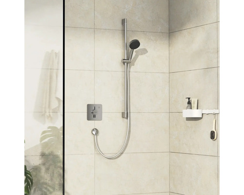 Duscharmatur mit Brausestange und Ablage im Badezimmer.