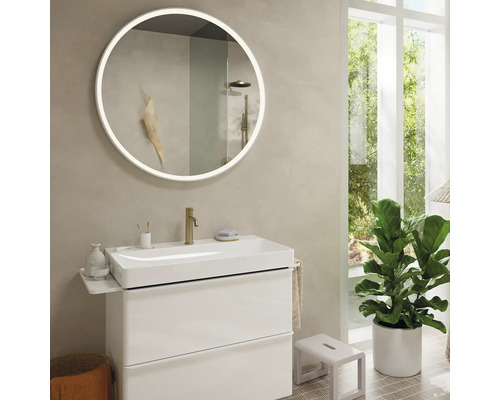 Modernes Badezimmer mit rundem Spiegel, Waschbeckenunterschrank und Zimmerpflanze