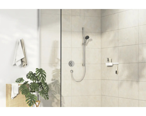 Helles Badezimmer mit Dusche, Handtüchern und Pflanze