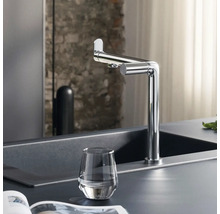 Küchenszene mit Spültischarmatur, Spüle und Glas Wasser