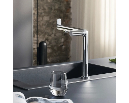 Küchenszene mit Spültischarmatur, Spüle und Glas Wasser